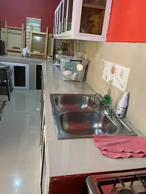 a kitchen with a stainless steel sink and red walls at Rancho Doña Rita in Higuey