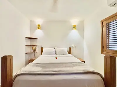 a bedroom with a bed with white sheets and a window at Family Villa Terrenas Samana Near the Beach in Las Terrenas