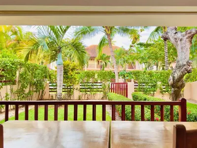 a porch with a bench and palm trees at Family Villa Terrenas Samana Near the Beach in Las Terrenas