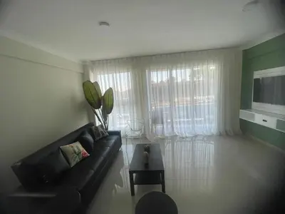 a living room with a black couch and a window at 2 Bdrm, 1 Bath, Wifi, Near River and Beach, 4R in Paraíso