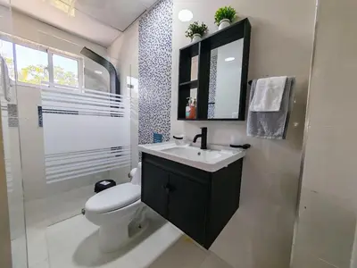 a bathroom with a toilet and a sink and a mirror at 2 Bdrm, 1 Bath, Wifi, Near River and Beach, 4R in Paraíso