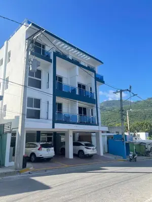 a white building with cars parked in front of it at 2 Bdrm, 1 Bath, Wifi, Near River and Beach, 4R in Paraíso