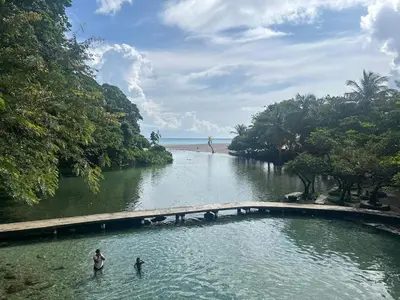 two people standing in the water near a river at 2 Bdrm 1 Bath Near River and Beach, 3L in Paraíso