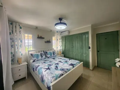 a bedroom with a bed with a blue and white comforter at Apartment-View-Beach-Mountains-Rivers-WiFi-AC-CLB in Santa Cruz de Barahona