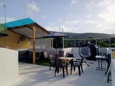 a patio with chairs and tables and an umbrella at Apartment-View-Beach-Mountains-Rivers-WiFi-AC-CLB in Santa Cruz de Barahona