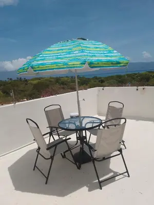 a table with chairs and an umbrella on a roof at Apartment-View-Beach-Mountains-Rivers-WiFi-AC-CLB in Santa Cruz de Barahona
