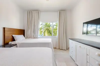 a hotel room with two beds and a television at First Line, Direct Access to Private Beach in Punta Cana