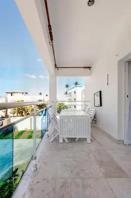 a balcony with a table and chairs and the ocean at First Line, Direct Access to Private Beach in Punta Cana