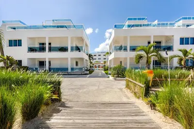 a walkway leading to two large white buildings at First Line, Direct Access to Private Beach in Punta Cana