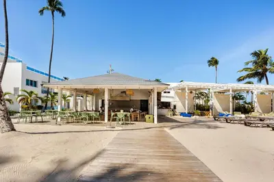 a house on the beach with palm trees and a boardwalk at First Line, Direct Access to Private Beach in Punta Cana
