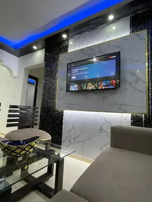 a living room with a table and a tv on a wall at Apartamento a 15 minutos de la playa in Imbert