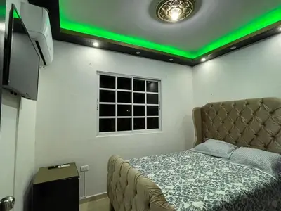 a bedroom with a bed with a green light at Apartamento a 15 minutos de la playa in Imbert