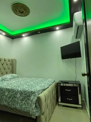 a bedroom with a bed and a green light at Departamento a 15 minutos de la playa in Imbert