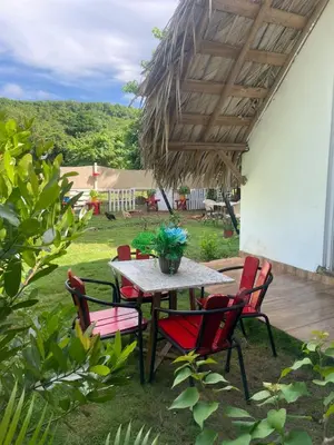a table and chairs under a wooden roof at Dreamvilles Ecovillage in Las Galeras