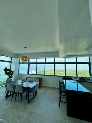a dining room with a table and chairs and windows at Juan Dolio 2BR Apt Beach front in Juan Dolio