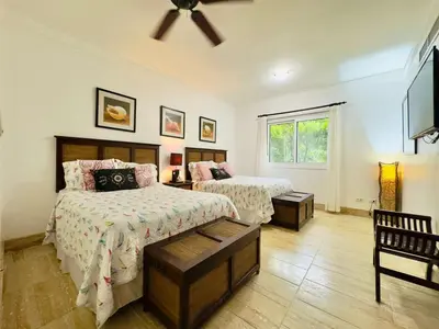 a bedroom with two beds and a flat screen tv at Oceanfront Unit Jacuzzi Balconies of Atlantic in El Limón