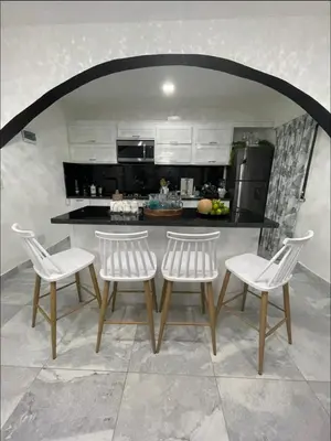 a kitchen with white chairs and a table and a counter at Alma Stay Central and cozy in Santa Bárbara de Samaná