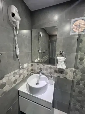 a bathroom with a sink and a shower with a phone at Alma Stay Central and cozy in Santa Bárbara de Samaná