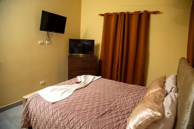 a bedroom with a bed and a tv and curtains at Modern 2BR Piscina BBQ Close To Kite Beach in Cabarete