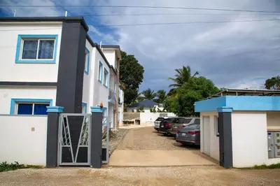 a house with a gate and cars parked in a driveway at Modern 2BR Piscina BBQ Close To Kite Beach in Cabarete