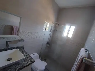 a bathroom with a shower and a toilet and a sink at Modern 2BR Piscina BBQ Close To Kite Beach in Cabarete