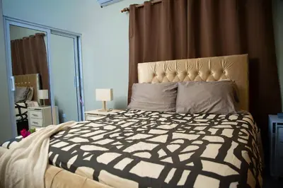 a bedroom with a bed with a black and white comforter at Modern 2BR Piscina BBQ Close To Kite Beach in Cabarete