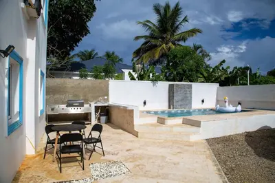 a patio with a table and chairs and a pool at Modern 2BR Piscina BBQ Close To Kite Beach in Cabarete