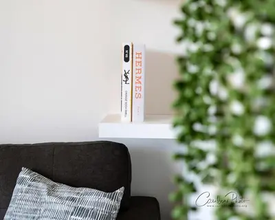 a book shelf next to a black couch with a pillow at Modern Caribbean Stay Coral Azul 301 in La Laguna