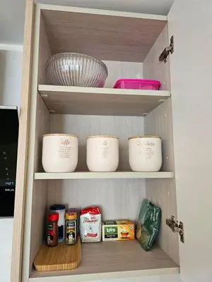a cabinet with bowls and other food items in it at Aqua Esmeralda Beachfront Apartment Trinidad 103 in La Laguna