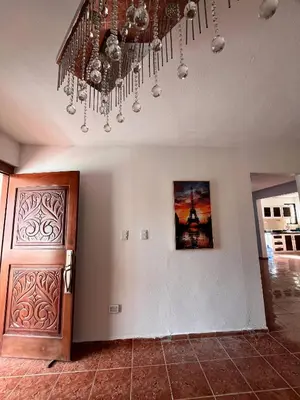 a living room with a chandelier and a wooden door at Beautiful Quiet shared home in Santo Domingo