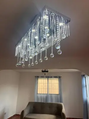a large chandelier hanging from a ceiling with a couch at Beautiful Quiet shared home in Santo Domingo