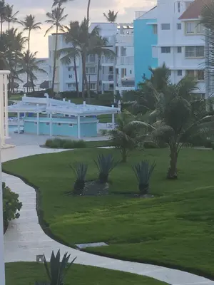 a golf course with palm trees and a building at my paradise in Punta Cana
