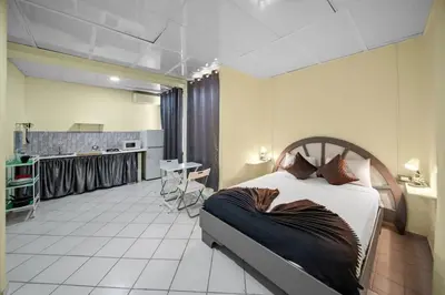 a bedroom with a large bed and a kitchen at Cheap Hotel Room in Sosua Strip in Sosúa