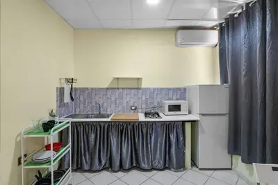 a small kitchen with a sink and a microwave at Cheap Hotel Room in Sosua Strip in Sosúa