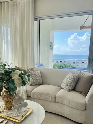 a living room with a couch and a large window at Majestic 2Bd Ocean view Apartment Boca Del Mar III in Boca Chica