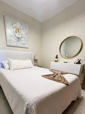 a bedroom with a white bed with a large mirror at Majestic 2Bd Ocean view Apartment Boca Del Mar III in Boca Chica