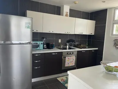 a kitchen with white cabinets and a stainless steel refrigerator at Spectacular Ocean View 1-Bedroom Condo, Vista Mare, Samana, DR in Villa Ramfis