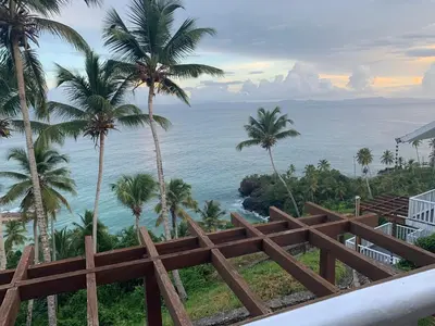a view of the ocean from a resort with palm trees at Spectacular Ocean View 1-Bedroom Condo, Vista Mare, Samana, DR in Villa Ramfis