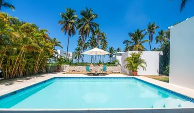 a swimming pool in a villa with palm trees at Lux villa playa bonita in Las Terrenas