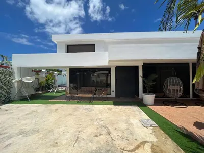 a white house with a patio with chairs at Villa fantastica Pool privada y centrica in Las Terrenas