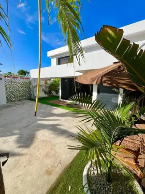 a house with a palm tree in front of it at Villa fantastica Pool privada y centrica in Las Terrenas