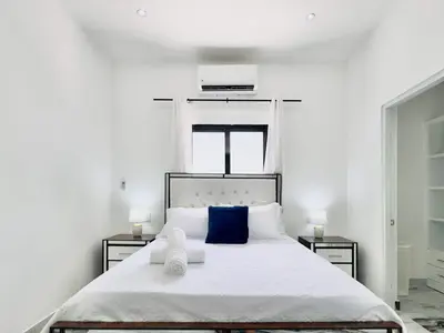 a bedroom with a large white bed with blue pillows at Villa Las Terrenas Near Playa Bonita Pool in Las Terrenas
