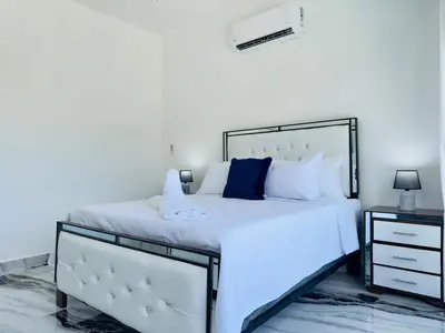 a bedroom with a large white bed with blue pillows at Villa Las Terrenas Near Playa Bonita Pool in Las Terrenas