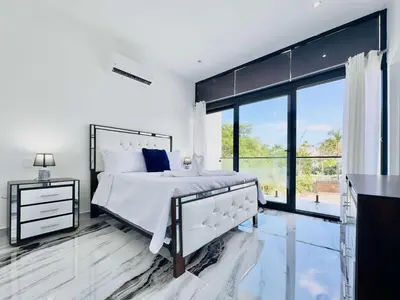 a white bedroom with a bed and a large window at Villa Las Terrenas Near Playa Bonita Pool in Las Terrenas