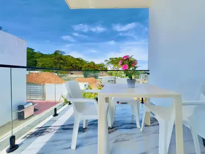 a white table and chairs on a balcony with a view at Villa Las Terrenas Cosón minutes Pool and AC in Las Terrenas
