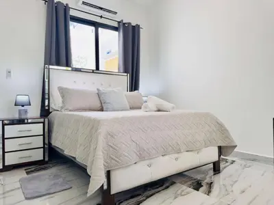 a bedroom with a white bed and a window at Villa Las Terrenas Cosón minutes Pool and AC in Las Terrenas