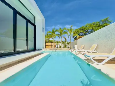 a swimming pool with chairs and a house at Villa Las Terrenas Cosón minutes Pool and AC in Las Terrenas