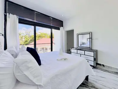 a bedroom with a white bed with a large window at Villa Las Terrenas walk to Punta Popy Pool, AC in Las Terrenas