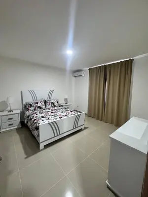 a white bedroom with a bed and a window at Modern apartment in Santo Domingo in Juan López