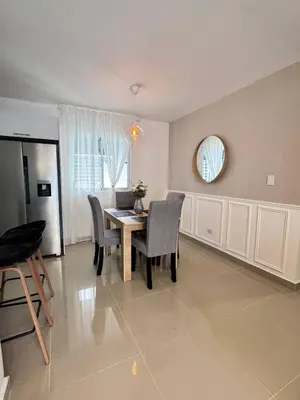 a dining room with a table and chairs and a mirror at Modern apartment in Santo Domingo in Juan López